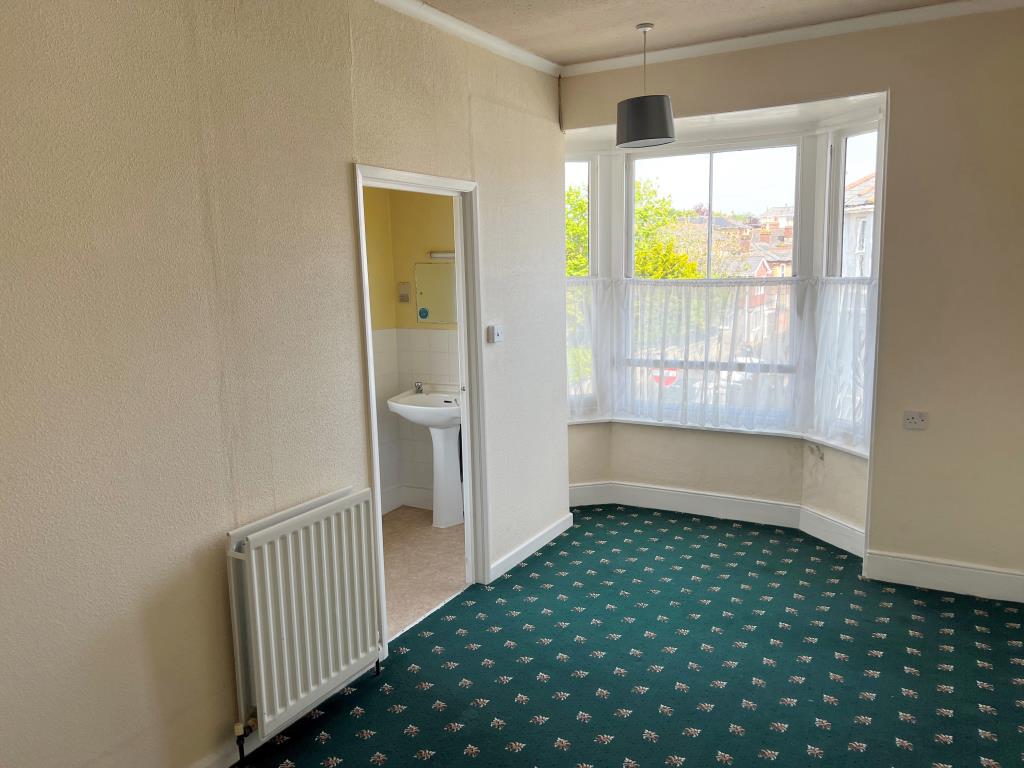 Lot: 164 - TOWN CENTRE SIX-BEDROOM HOUSE WITH POTENTIAL - A first floor bedroom with the doorway to the en-Suite